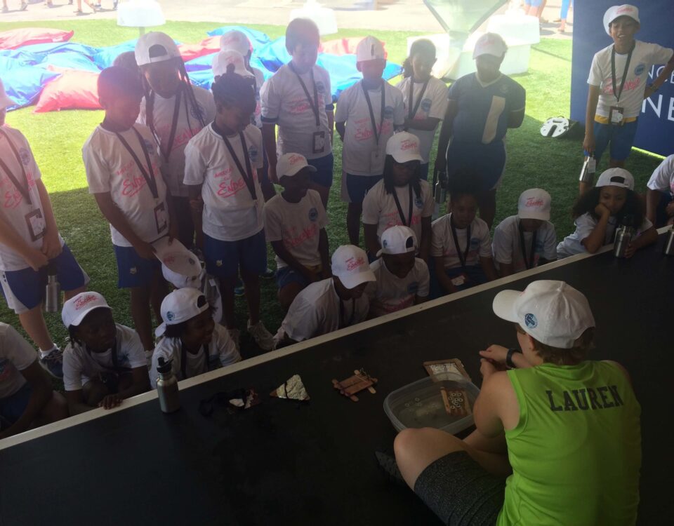 Staff member running experiment with students looking on.