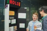 Adult discusses Mold experiment with student.