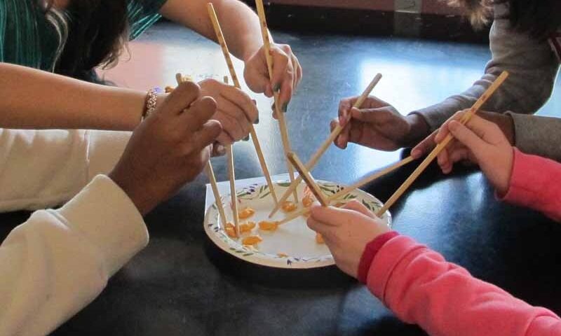 Students using chopsticks to fish.