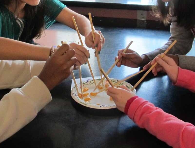Students using chopsticks to fish.